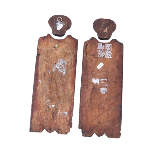 315 - An early pair of carved oak leaf form figures with detached heads, 39cms high.