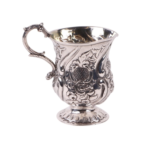 404 - A Victorian Irish silver cream jug with repousse decoration, the handle terminating in a dolphin,  D... 