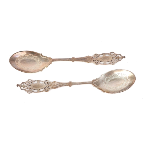 409 - A pair of Edwardian ornate pierced and engraved silver preserve spoons in original fitted case, Shef... 