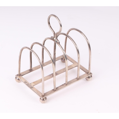 419 - A silver four-division toast rack on ball feet, 8.5cms long, 82g.