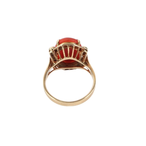 527 - A 14ct gold ring set with a central coral cabochon flanked by four diamonds, approx UK size O, 5.4g.