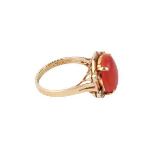 527 - A 14ct gold ring set with a central coral cabochon flanked by four diamonds, approx UK size O, 5.4g.