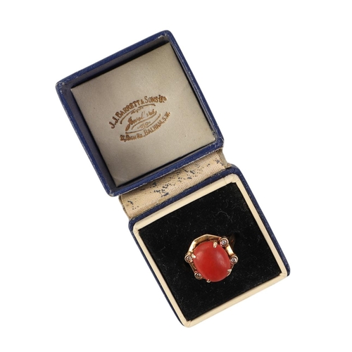 527 - A 14ct gold ring set with a central coral cabochon flanked by four diamonds, approx UK size O, 5.4g.