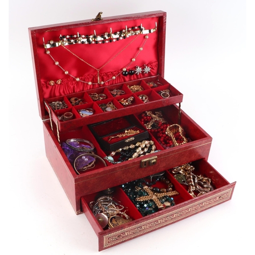 539 - A large quantity of costume jewellery to include necklaces, brooches and rings, in a red jewellery b... 