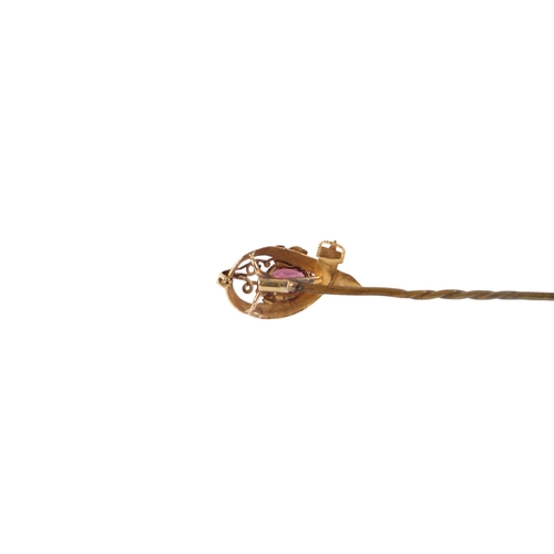 543 - A Victorian yellow metal stick pin of strap and buckle design, set with a single garnet, boxed.