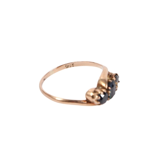 559 - A 9ct gold ring set with three dark blue stones, approx UK size P, 2.1g.