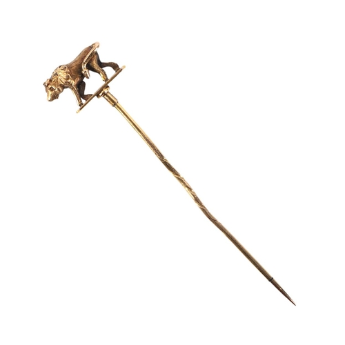 569 - A Victorian yellow metal stick pin, the terminal in the form of a bull, 7cms long, 3g.