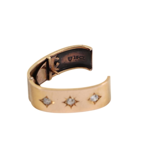 570 - A 15ct gold scarf ring set with three diamonds.