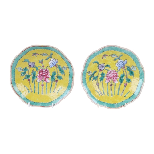 594 - A pair of Chinese famille vert shaped footed bowls decorated with flowers on a yellow ground within ... 