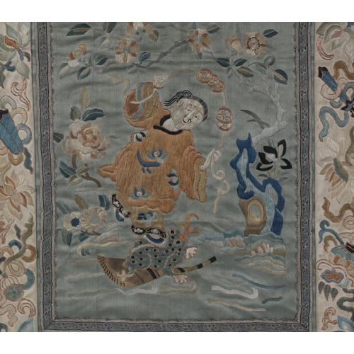 598 - A Chinese silk embroidered panel depicting Liu Hai Chan standing on a three legged toad with auspici... 