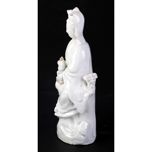 605 - A Chinese blanc de chine figure depicting Guanyin, 25cms high (a/f).