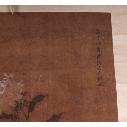 609 - A Chinese scroll painting depicting peonies, overall 60 by 151cms.