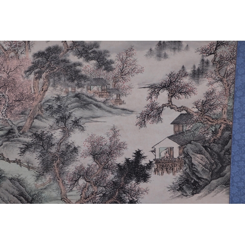 612 - A Chinese scroll depicting a mountainous landscape scene with calligraphy, 62 by 127cms.