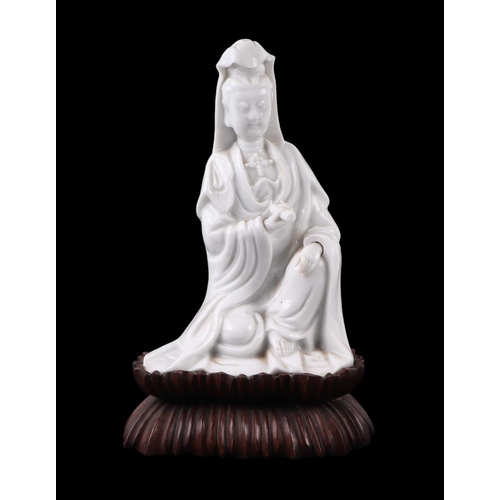 621 - A Chinese blanc de chine figure depicting Guanyin, on a hardwood lotus flower base, 22cms overall he... 