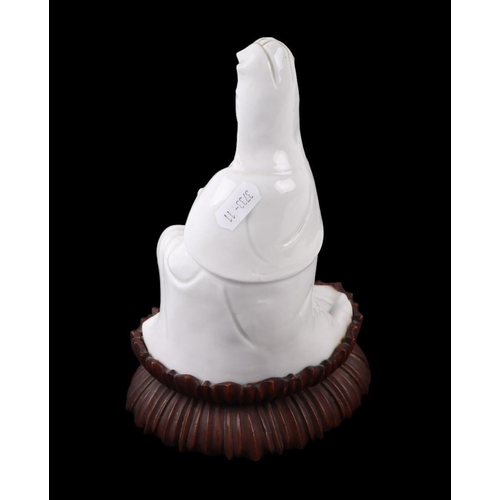 621 - A Chinese blanc de chine figure depicting Guanyin, on a hardwood lotus flower base, 22cms overall he... 