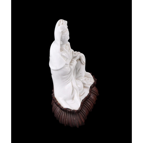 621 - A Chinese blanc de chine figure depicting Guanyin, on a hardwood lotus flower base, 22cms overall he... 