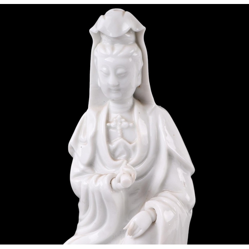 621 - A Chinese blanc de chine figure depicting Guanyin, on a hardwood lotus flower base, 22cms overall he... 