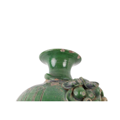 622 - A Chinese green glazed pottery vase decorated with grapes and vine, 17cms high.