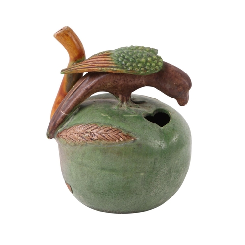 626 - A pottery water dropper in the form of a parrot perched on an apple, 9cms high.