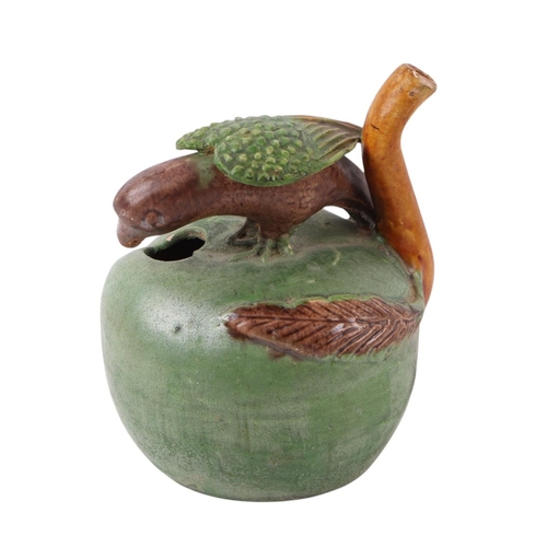 626 - A pottery water dropper in the form of a parrot perched on an apple, 9cms high.