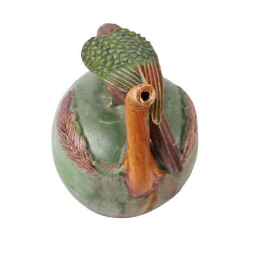 626 - A pottery water dropper in the form of a parrot perched on an apple, 9cms high.