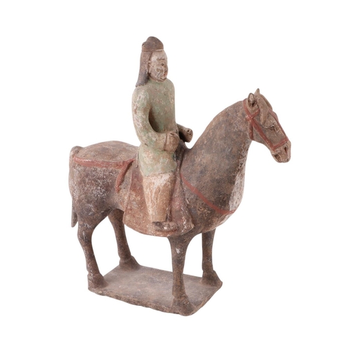 631 - A Chinese Tang Dynasty style polychrome painted terracotta model of a horse and rider, 32cms high to... 