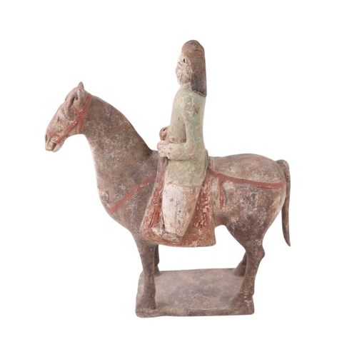 631 - A Chinese Tang Dynasty style polychrome painted terracotta model of a horse and rider, 32cms high to... 