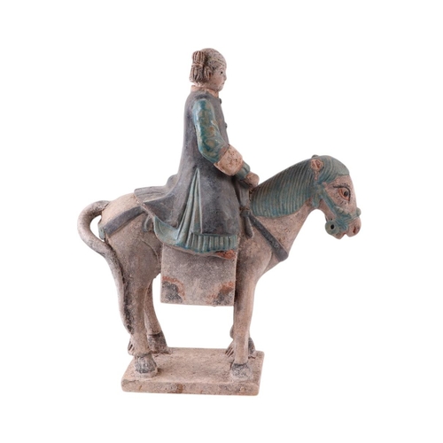 632 - A Chinese Tang Dynasty style polychrome painted terracotta model of a horse and rider, 33cms high.