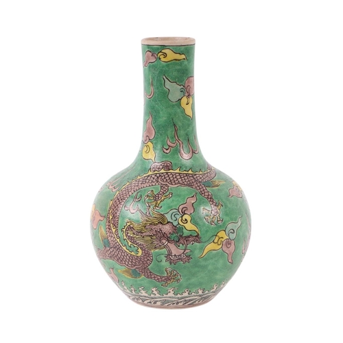 635 - A Chinese bottle vase decorated with a dragon chasing a flaming pearl, on a green ground, 19cms high... 