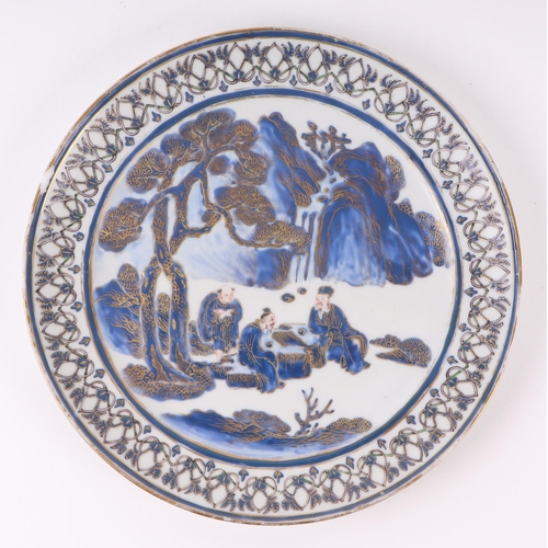 649 - A Chinese blue & white plate decorated with figures playing a board game under a fir tree, with gilt... 