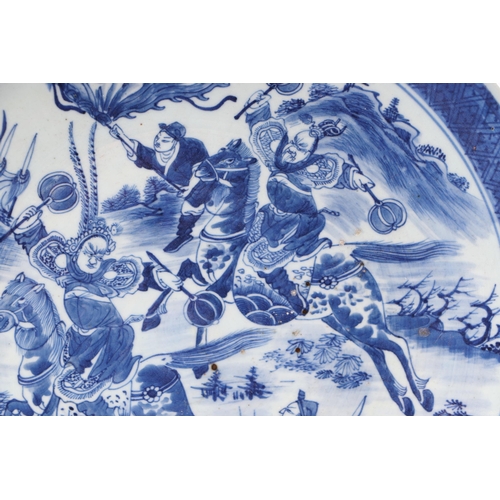 670 - A Chinese blue & white charger decorated with warriors on horseback, 41cms diameter.