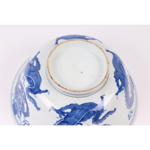 673 - A Chinese blue & white bowl decorated with dragons, 20cms diameter; together with a Chinese blue & w... 