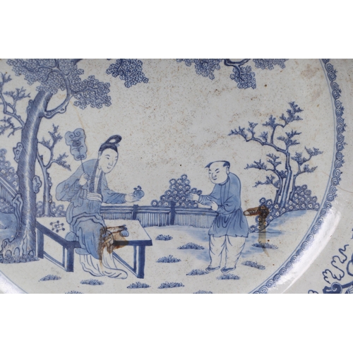 674 - A large Chinese blue & white charger decorated with figures in a garden, 54cms diameter.