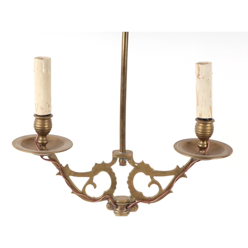 694 - A brass twin-arm table lamp surmounted a twin headed eagle, 73cms high.