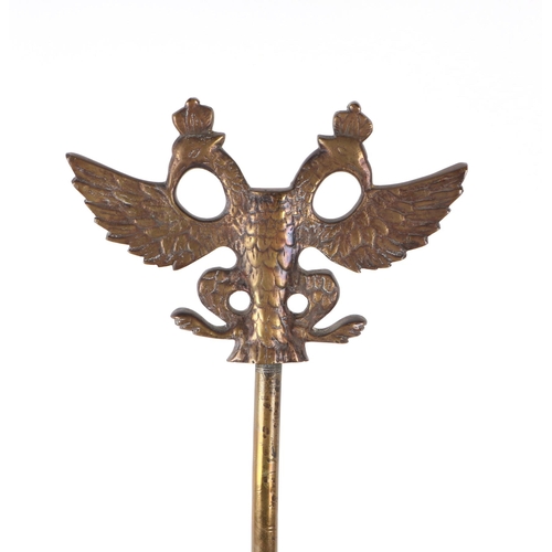 694 - A brass twin-arm table lamp surmounted a twin headed eagle, 73cms high.