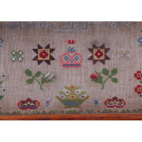 708 - A Victorian sampler with alphabet, flowers and a crown, by Jane E Cowton Aged 9, 1876, framed and gl... 