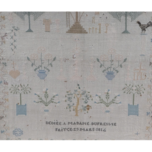 711 - An early 19th century French needlework sampler dated 1814, worked in pale colours with a crucifix b... 