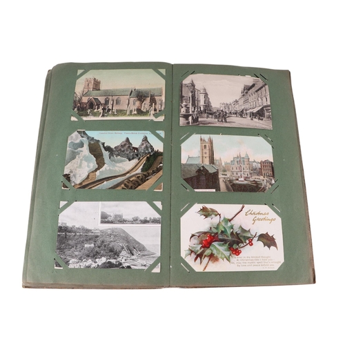 722 - An Edwardian postcard album containing topographical and comical cards; together with some loose pos... 