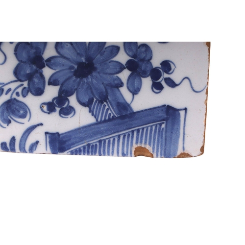 753 - A mid 18th century English Delft flower brick decorated with a fence, flowers and leaves, 16cms wide... 