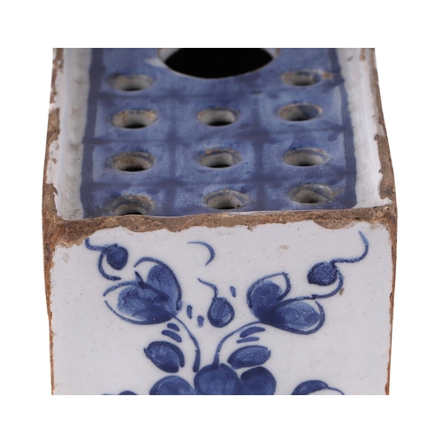 753 - A mid 18th century English Delft flower brick decorated with a fence, flowers and leaves, 16cms wide... 