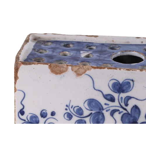 753 - A mid 18th century English Delft flower brick decorated with a fence, flowers and leaves, 16cms wide... 