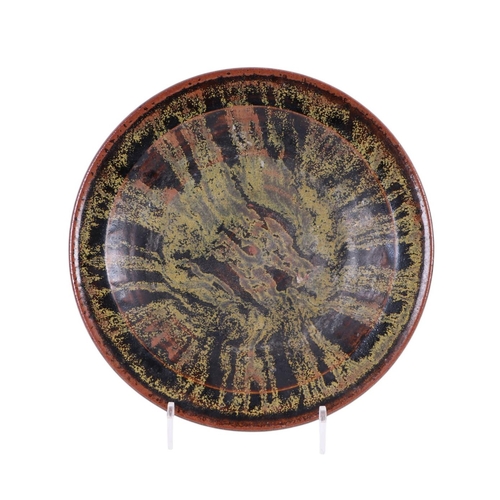 766 - A glazed Studio pottery plate with impressed mark to the underside, 33cms diameter.