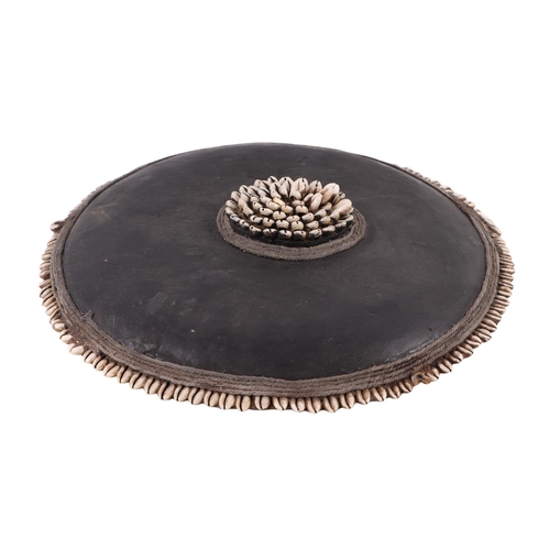 800 - A circular tribal shield decorated with cowrie shells, 43cms diameter.