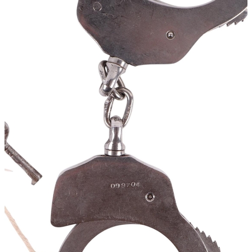 812 - A pair of HWC stainless steel vintage handcuffs in a leather pouch.