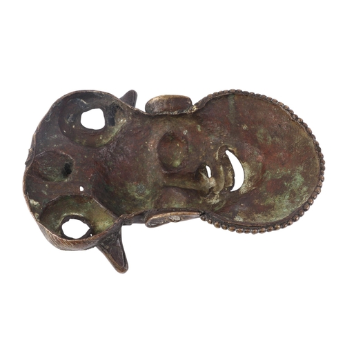 83 - An African Benin bronze wall mask with stylised bearded face, having a coiled snake and toad headdre... 