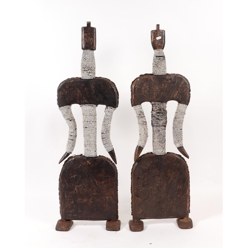 84 - A pair of African tribal Namji figures with cowrie shell decoration, each 103cms high (2).