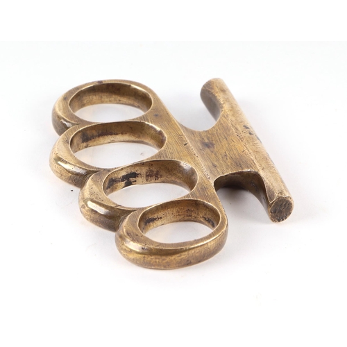 840 - A WWI trench combat knuckle duster, of bronze/brass construction with four finger holes, unmarked, 9... 