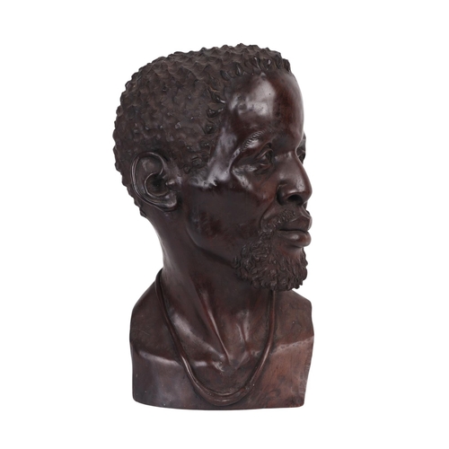 86 - Israel Chikumbirike (Zimbabwe school b1954) - a large carved ebony bust of an African man wearing a ... 