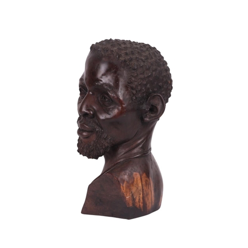 86 - Israel Chikumbirike (Zimbabwe school b1954) - a large carved ebony bust of an African man wearing a ... 