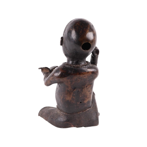 87 - A large antique African bronze figure of a boy holding a book, 34cms high.